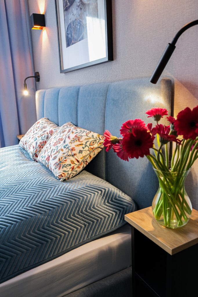 Apartamenty w Sarbinowie – sypialnia z kwiatami i dużym łóżkiem