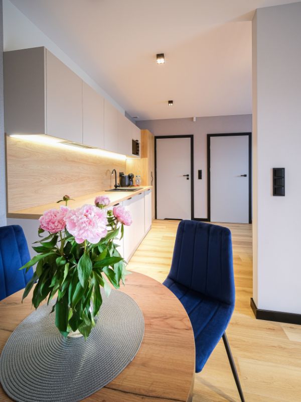 Apartamenty w Sarbinowie – salon z aneksem kuchennym i stołem